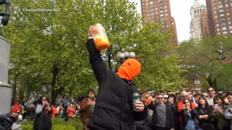 Hundreds Gather to Watch Masked Man Eat an Entire Jar of Cheeseballs in New York City